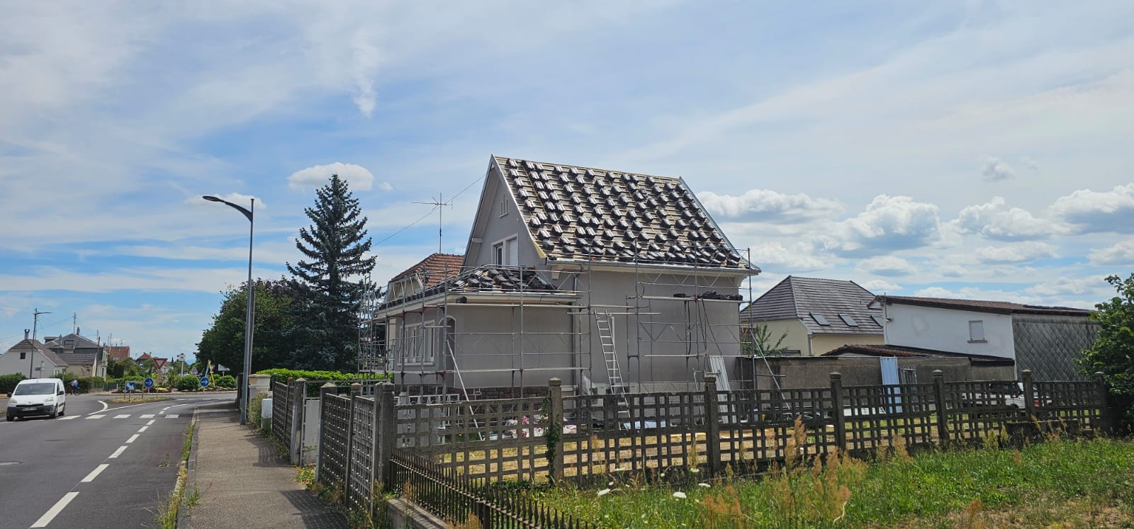 Pose des tuiles neuves en cours sur une toiture rénovée du Sundgau