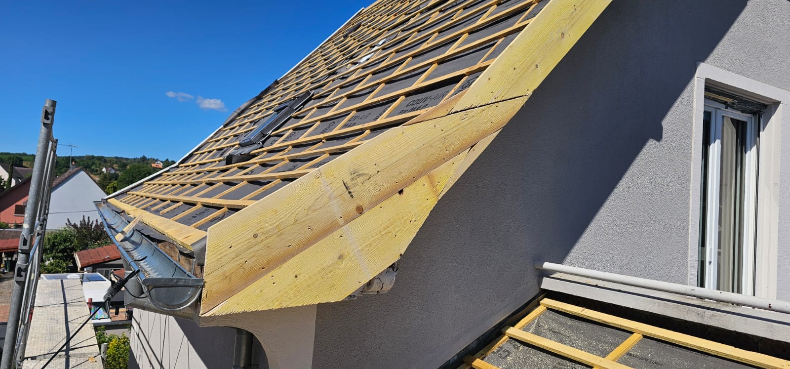 Rive de toiture neuve et gouttière zinc sur une maison rénovée du Haut-Rhin